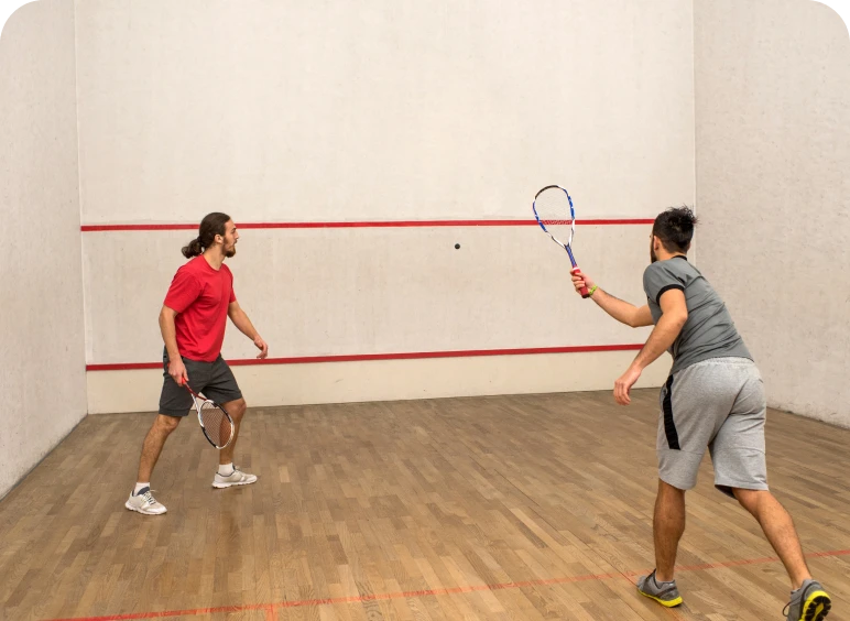 Two men playing squash on court.