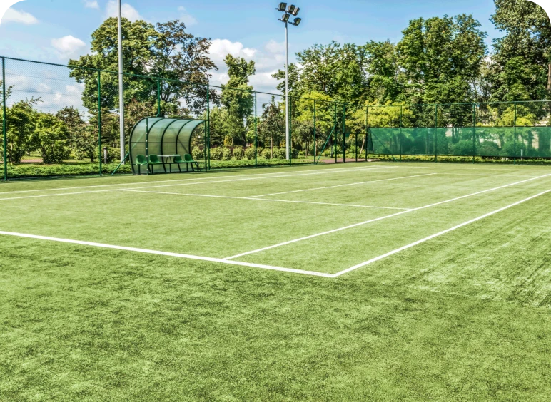 Grass tennis court with green surroundings.