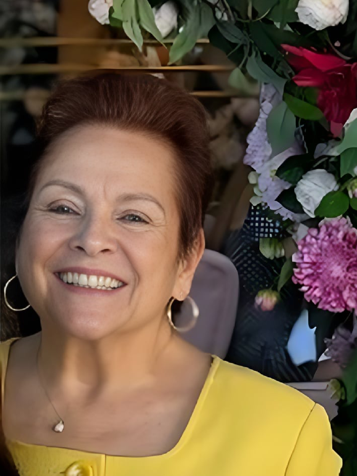 Smiling woman in vibrant yellow outfit.